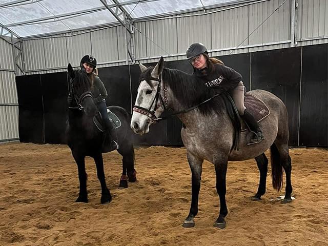 Dwie dziewczyny siedzące na koniach